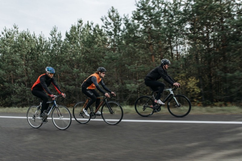 Three cyclists riding together on a road